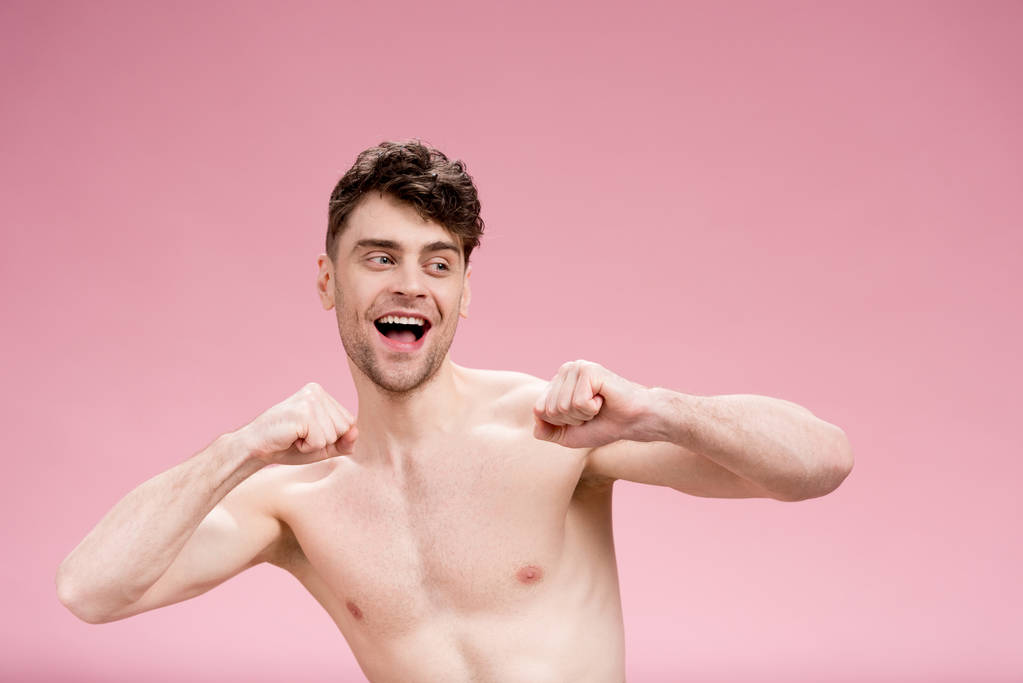 vrolijke, knappe naakte man gebaren op roze - Foto, afbeelding