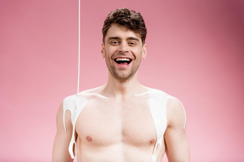 hymyilevä mies valkoisella maalilla roiskuu kehossa katsoen kameraa vaaleanpunaisella
 - Valokuva, kuva
