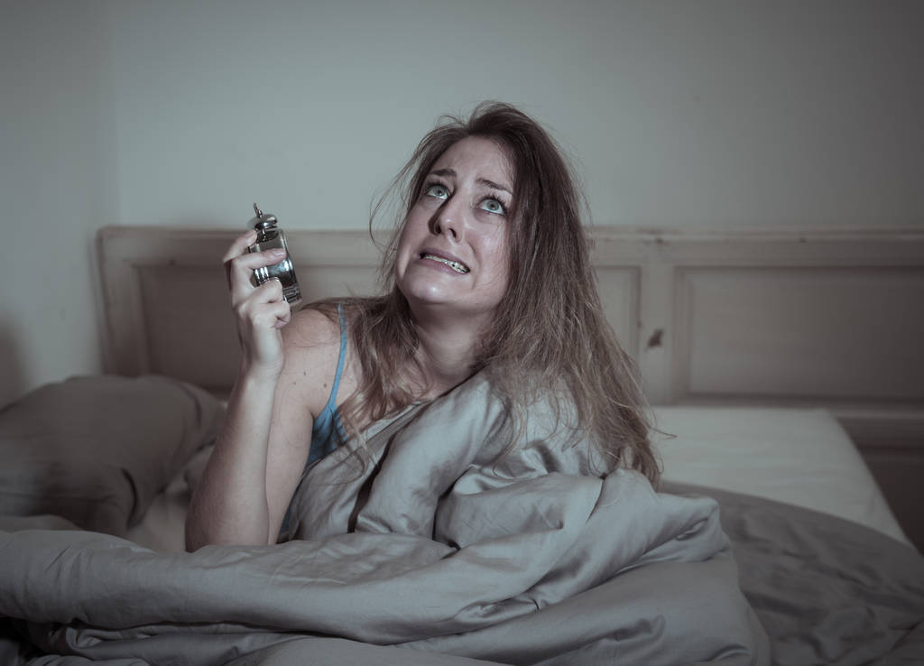 schlaflose und verzweifelte schöne kaukasische Frau, die nachts nicht schlafen kann, Uhr zeigt, sich frustriert und besorgt fühlt und unter Schlafstörungen leidet. - Foto, Bild