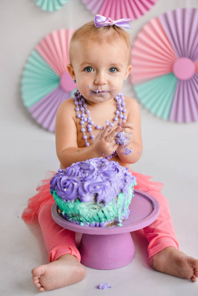 birthday girl was smeared into a cake. The first cake. The use of the first cake. Smash cake. holiday decor photo shoot crush cake - Photo, Image