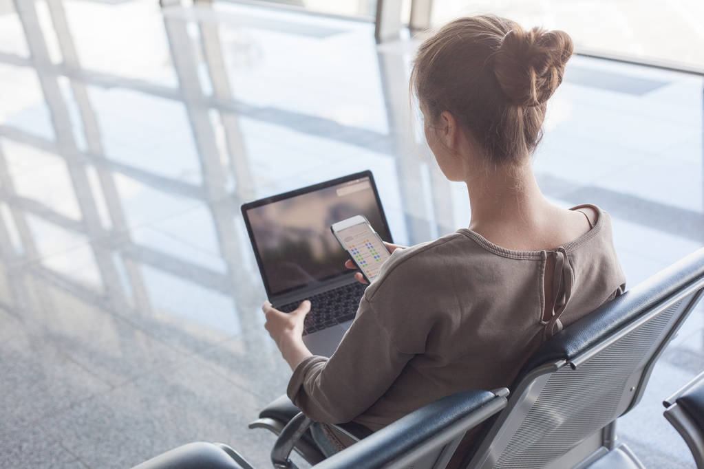 mujer que trabaja con el ordenador portátil en el aeropuerto esperando su vuelo
 - Foto, imagen