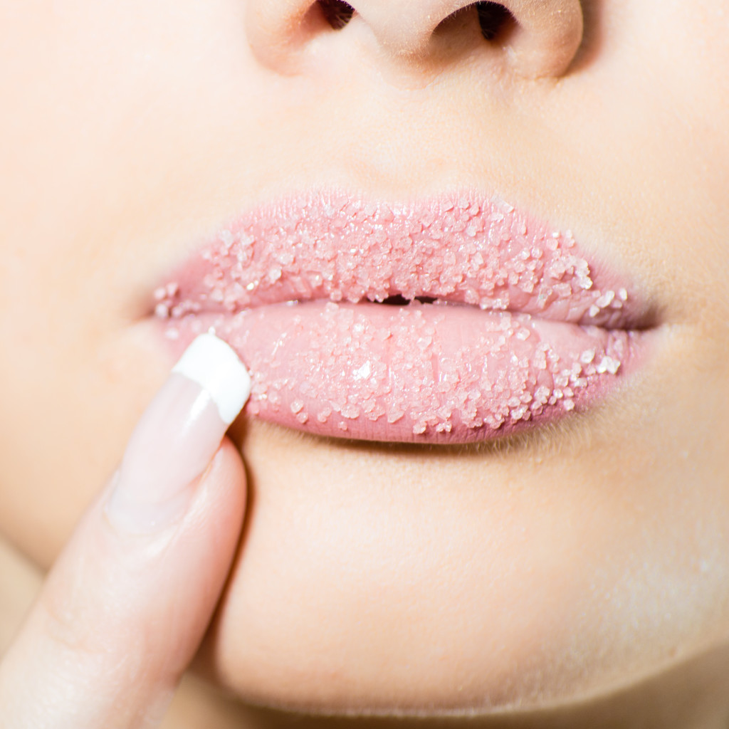 Closeup on female sweet sugary lips with finger nicely manicured - Photo, Image
