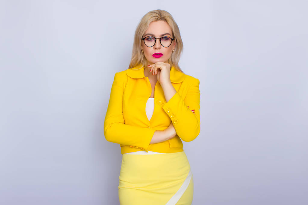 Zakenvrouw in geel pak en brillen - Foto, afbeelding