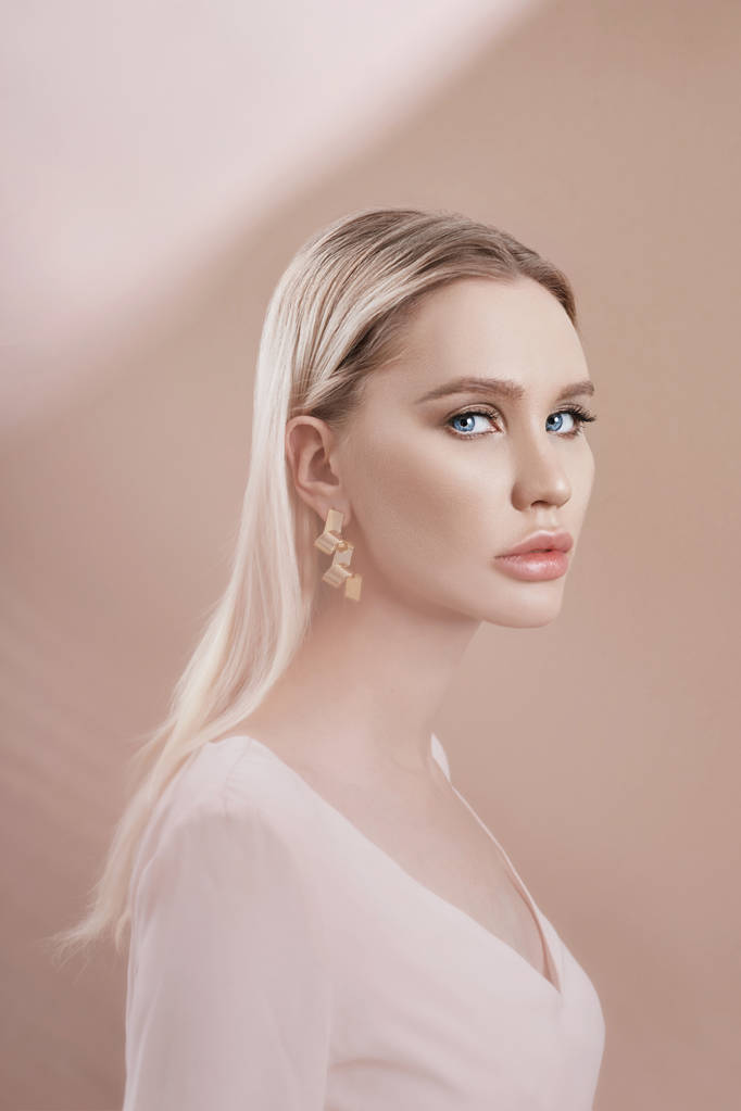 Oorbellen en juwelen in het oor van een sexy blonde vrouw via een tra - Foto, afbeelding