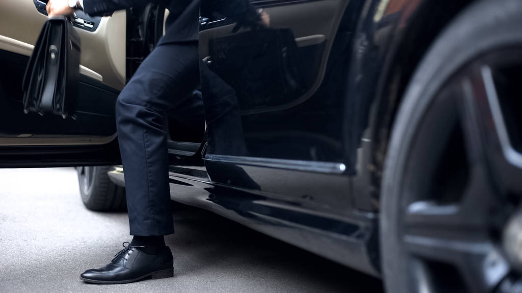 Erfolgreicher Geschäftsmann steigt aus dem Auto der Oberklasse aus, Ankunft am Arbeitsplatz - Foto, Bild