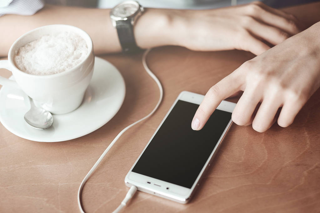 Mains de femme avec téléphone intelligent, écouteurs et tasse de thé. Pour montage d'affichage graphique - Photo, image