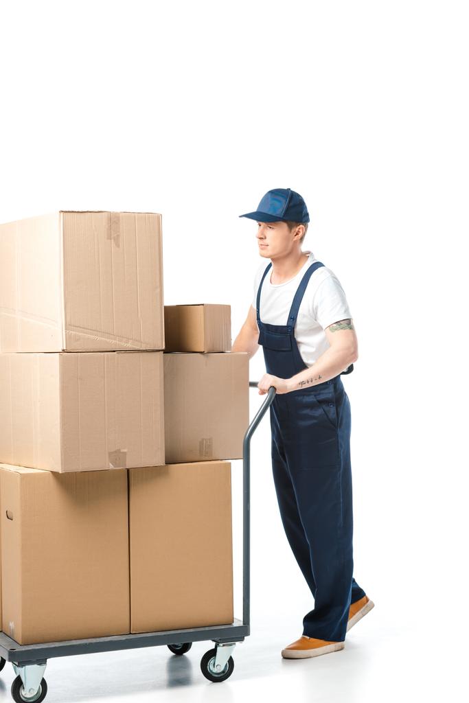 bel traslocatore in uniforme che trasporta scatole di cartone su camion a mano isolato su bianco
 - Foto, immagini