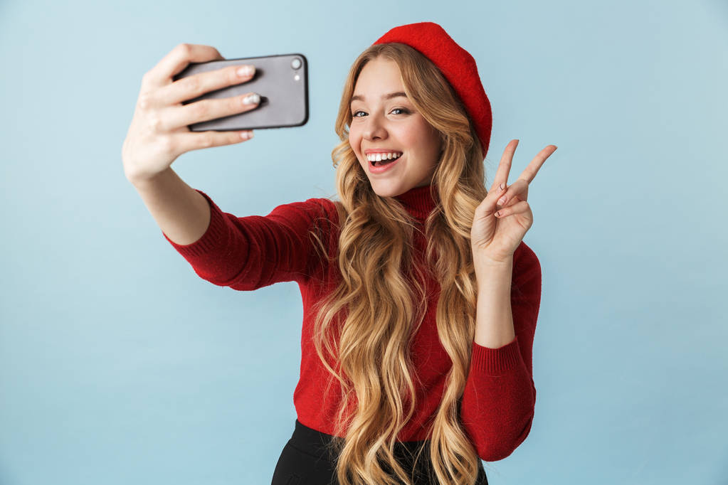 Zdjęcie z Blondynka 20s noszenie czerwony beret biorąc selfie na mobi - Zdjęcie, obraz