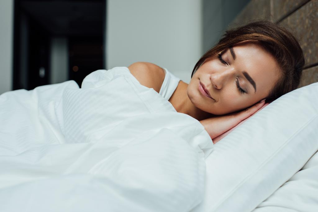 Piękna Brunetka kobieta spanie na poduszkę pod koc w łóżku  - Zdjęcie, obraz