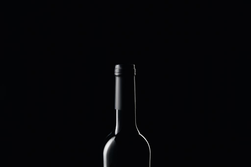 Verre bouteille de vin dans l'obscurité isolé sur noir
 - Photo, image