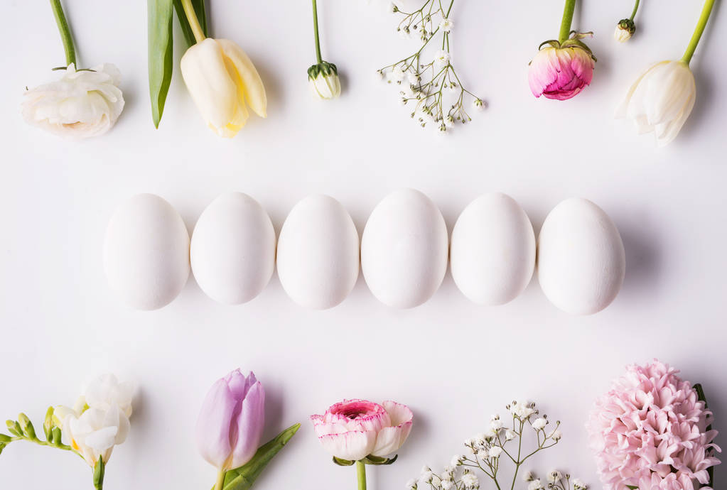 Çiçekler ve beyaz zemin üzerine beyaz yumurta. Düz yatıyordu. - Fotoğraf, Görsel