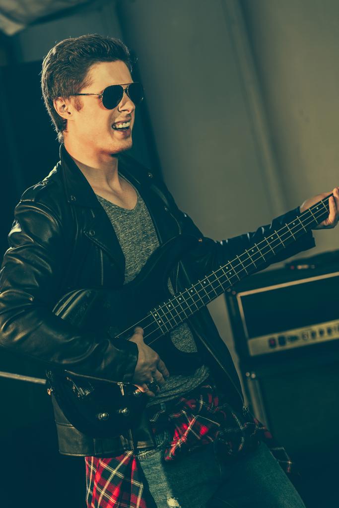 όμορφος κιθαρίστας με γυαλιά ηλίου performing επί σκηνής  - Φωτογραφία, εικόνα