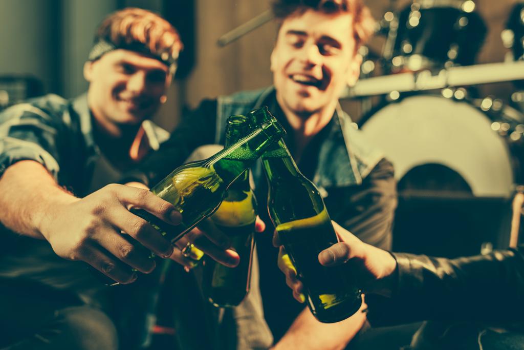 selective focus of glass bottles in hands of cheerful friends  - Photo, Image