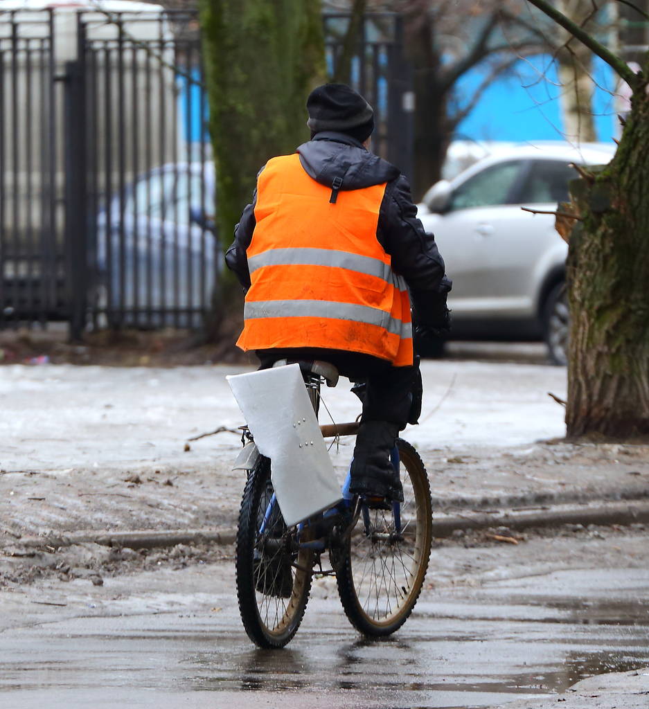 L'employé du service municipal pour le nettoyage des rues sur un vélo avec une pelle
 - Photo, image