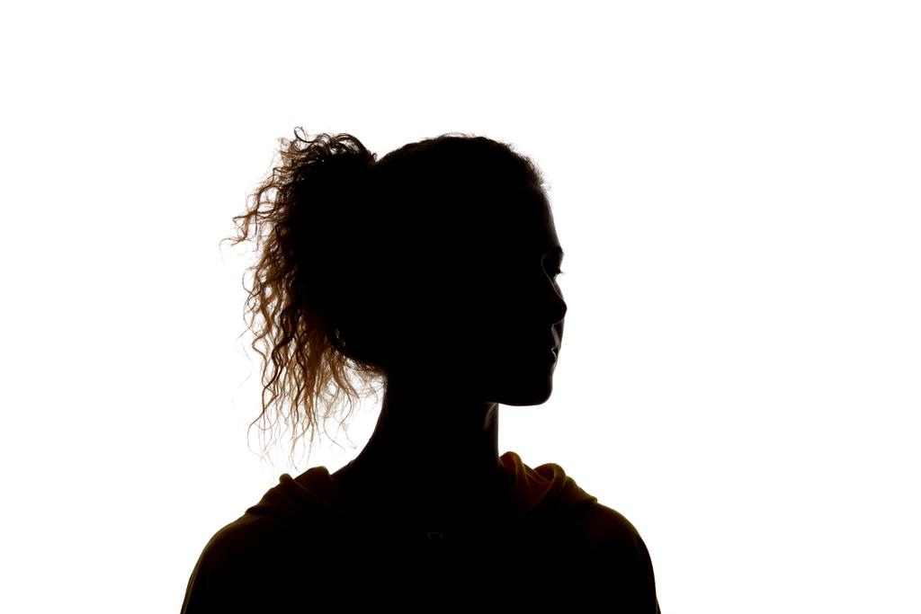 Silhouet van krullend meisje met paardenstaart geïsoleerd op wit - Foto, afbeelding