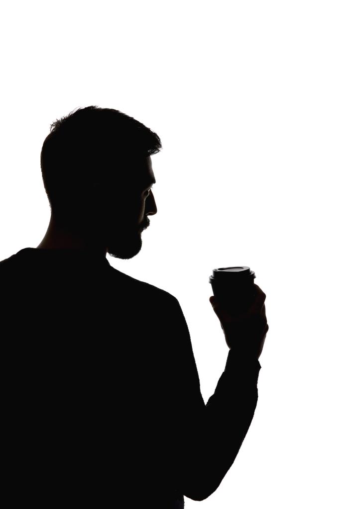 Silueta de hombre sosteniendo taza de papel de café aislado en blanco
 - Foto, Imagen