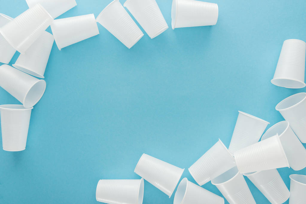 top view of white plastic cups on blue background with copy space  - Photo, Image
