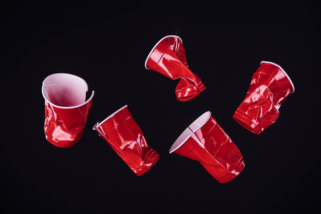 top view of bright and colorful, red plastic cups isolated on black with copy space  - Photo, Image