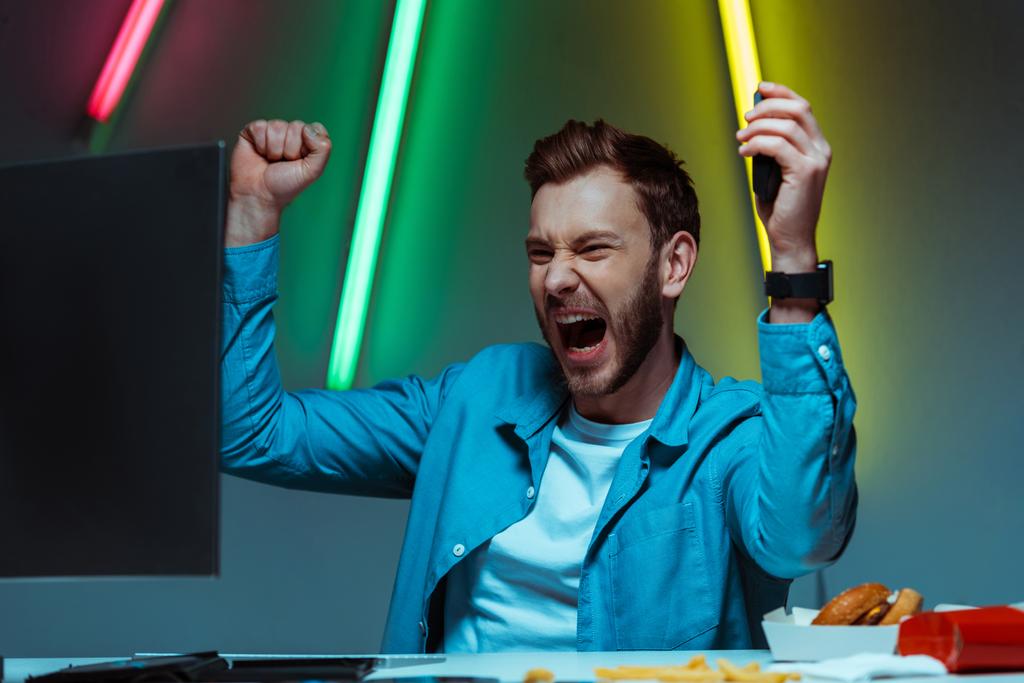 hombre guapo y feliz sosteniendo el ratón de la computadora y mostrando sí gesto
 - Foto, imagen
