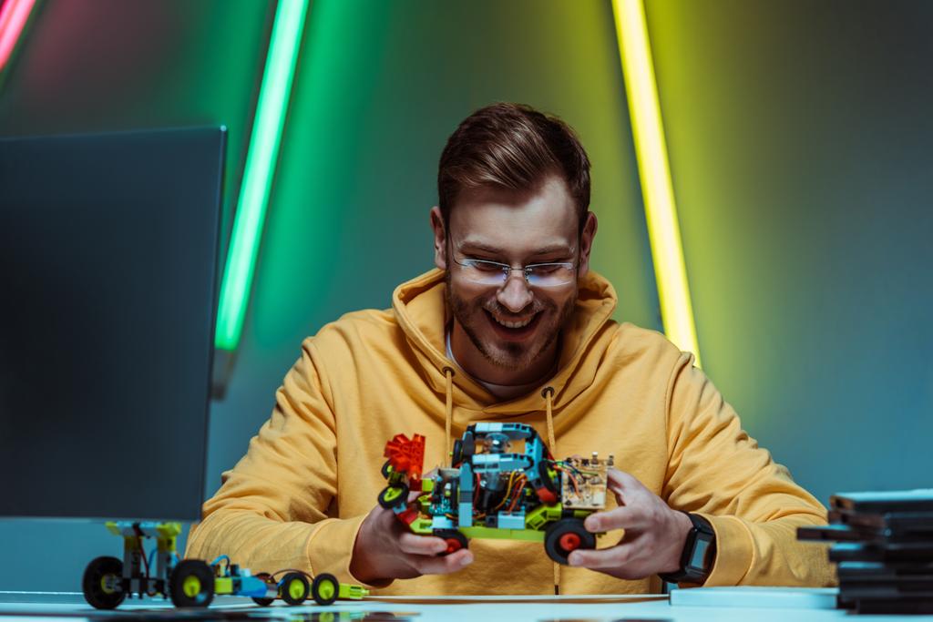 sorridente e bonito homem de óculos brincando com construtor de brinquedos
  - Foto, Imagem