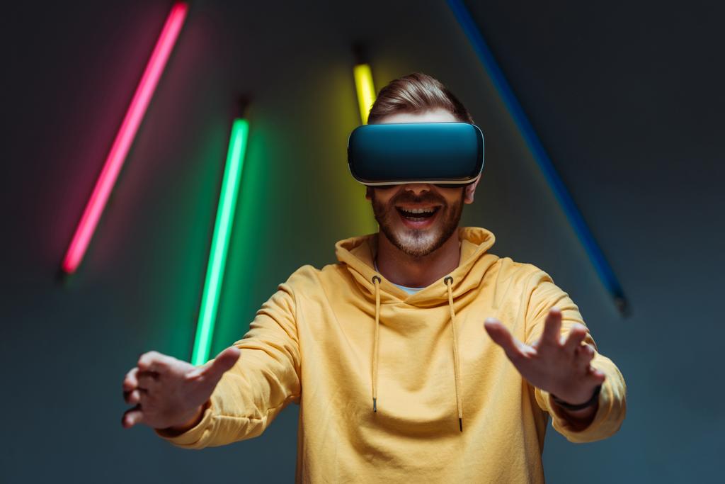 adulto joven y hombre guapo jugando en auriculares de realidad virtual
 - Foto, Imagen
