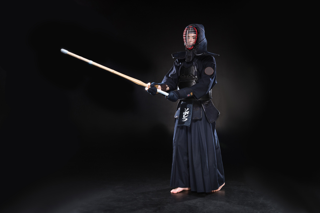 Προβολή πλήρους μήκους μαχητής kendo με πανοπλία εξάσκηση με ξίφος μπαμπού σε μαύρο - Φωτογραφία, εικόνα