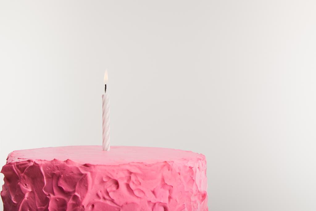 heerlijke roze verjaardagstaart met kaars geïsoleerd op grijs - Foto, afbeelding