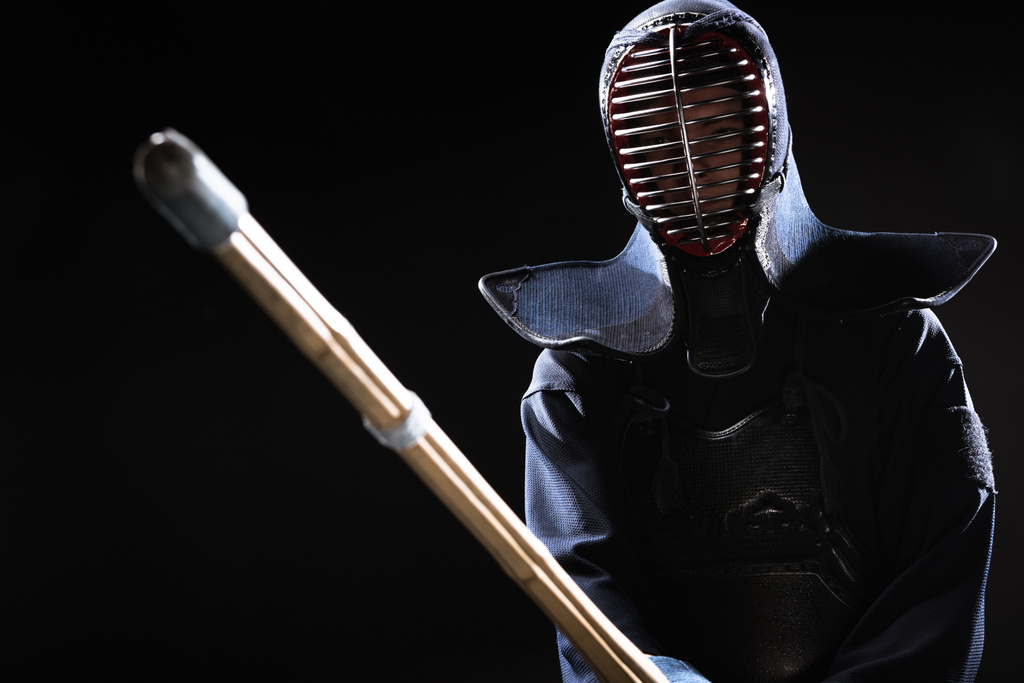 Боец Кендо в доспехах, практикующийся с бамбуковым мечом, изолированным на черном
 - Фото, изображение