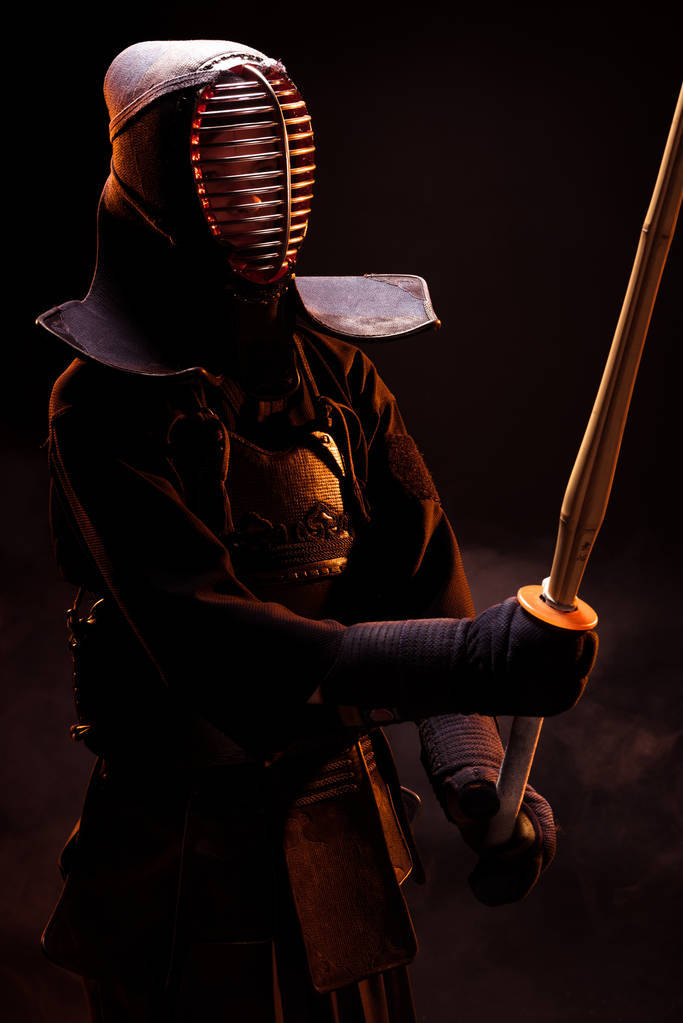 Кендо винищувач в броню практикуючих з бамбука меч на чорному - Фото, зображення