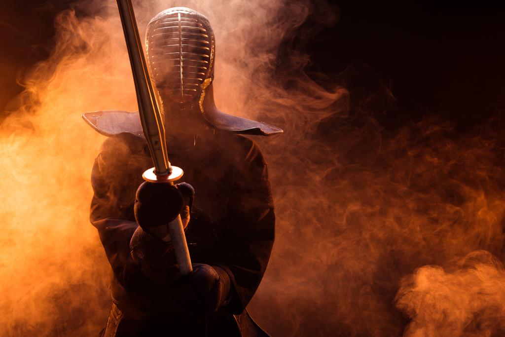 Kendo-Kämpfer in Rüstung mit Bambusschwert im Rauch - Foto, Bild