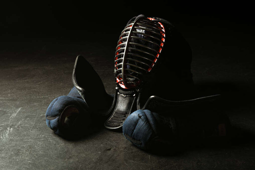 Guanti kendo e casco tradizionale su superficie scura
 - Foto, immagini