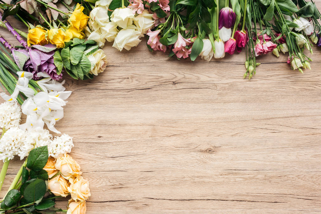 Το top view φρέσκα πολύχρωμα λουλούδια σε ξύλινη επιφάνεια - Φωτογραφία, εικόνα