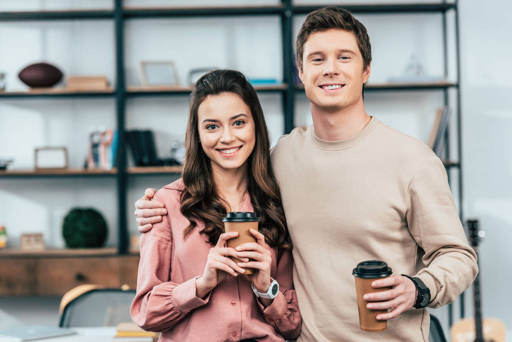 Dos amigos sonrientes sosteniendo tazas de café y mirando a la cámara
 - Foto, imagen