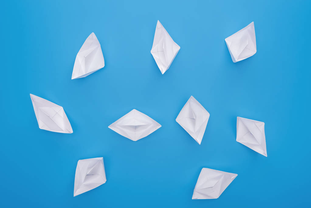 Top view of white paper boats on blue surface - Photo, Image