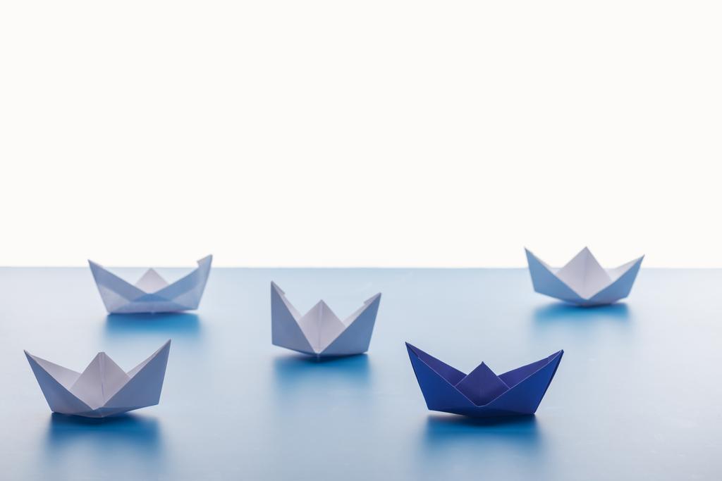 Paper boats on light blue surface on white background - Photo, Image