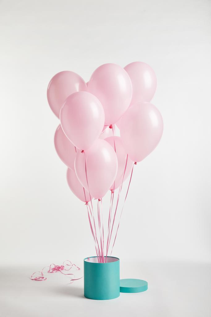 paquete de globos de aire festivos de color rosa con caja de regalo de turquesa en blanco
 - Foto, imagen