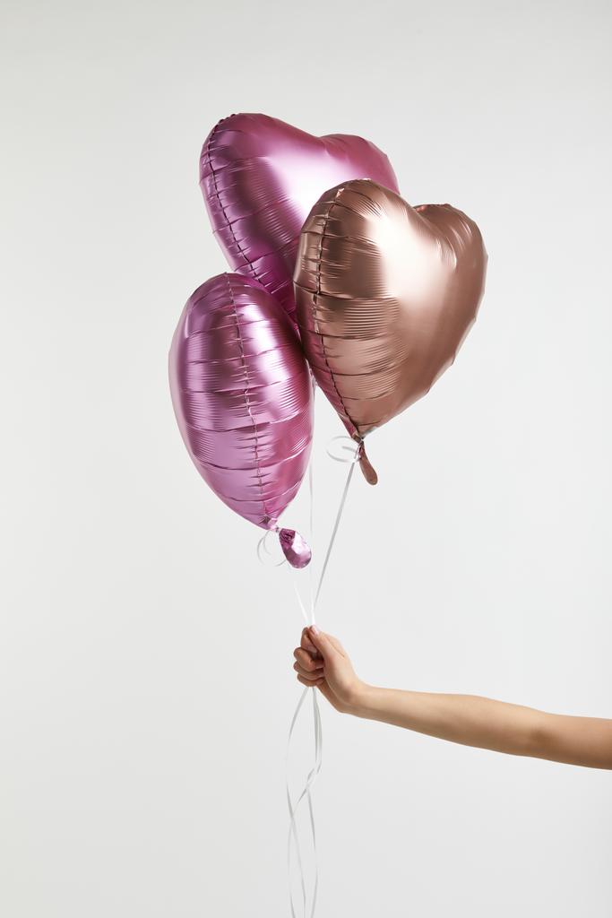 μερική άποψη της κοπέλα που κρατά την καρδιά-διαμορφωμένα ροζ αέρα μπαλόνια που απομονώνονται σε λευκό με αντίγραφο χώρου - Φωτογραφία, εικόνα