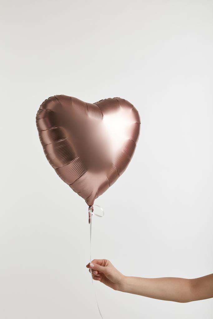 abgeschnittene Ansicht von Mädchen mit herzförmigen goldenen Luftballon isoliert auf weiß - Foto, Bild