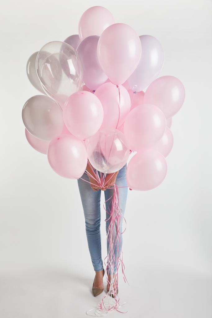 ragazza in denim faccia di copertura con palloncini d'aria rosa isolati su bianco
 - Foto, immagini