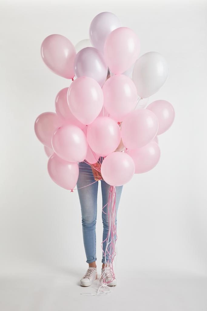 menina cobrindo rosto com balões de ar rosa isolado em branco
 - Foto, Imagem