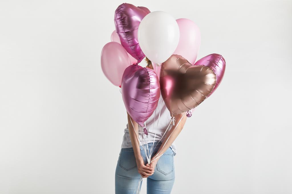 vista posteriore della ragazza in denim con palloncini rosa a forma di cuore isolati su bianco
 - Foto, immagini