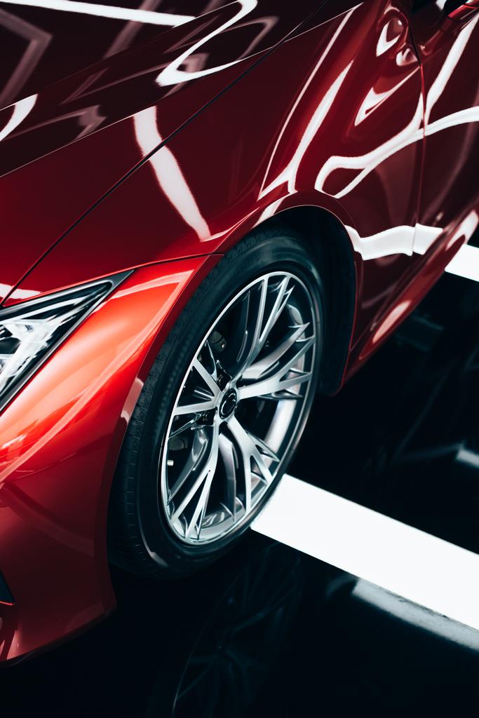 новый блестящий красный автомобиль с металлическим колесом в автосалоне
  - Фото, изображение