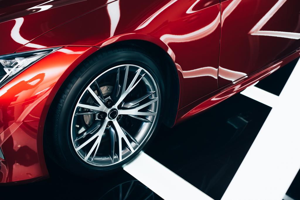 nuova automobile rossa lucida con ruota metallica nello showroom dell'automobile
  - Foto, immagini
