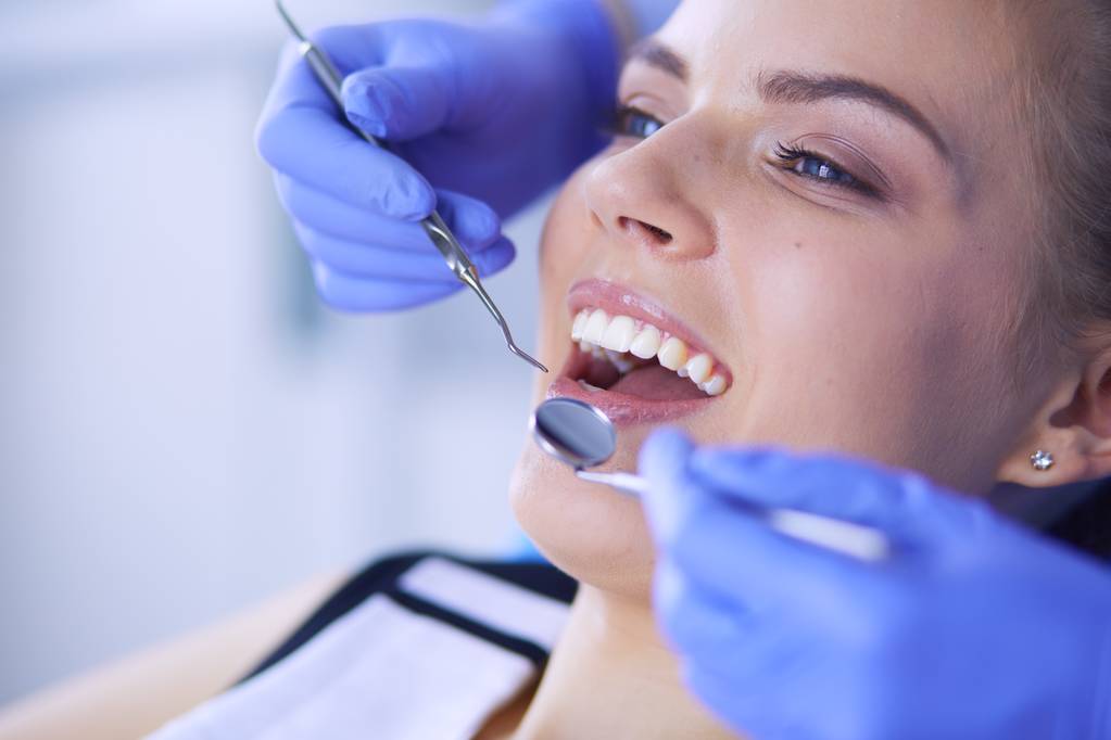 Jeune patiente à bouche ouverte examinant l'inspection dentaire au cabinet du dentiste. - Photo, image