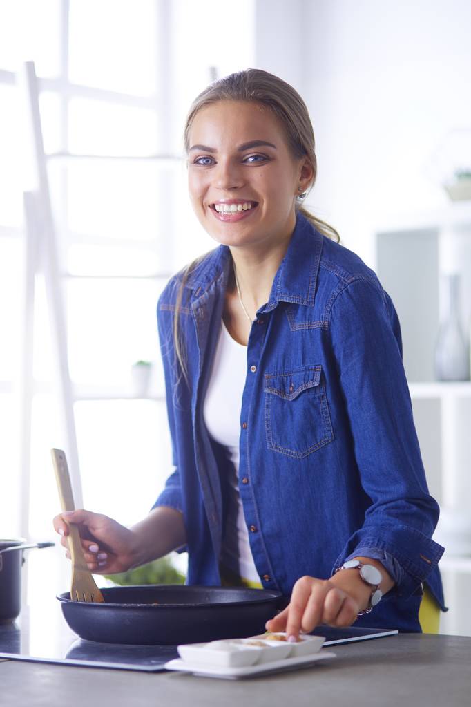 Junge Frau bereitet in der Küche ein Essen zu - Foto, Bild