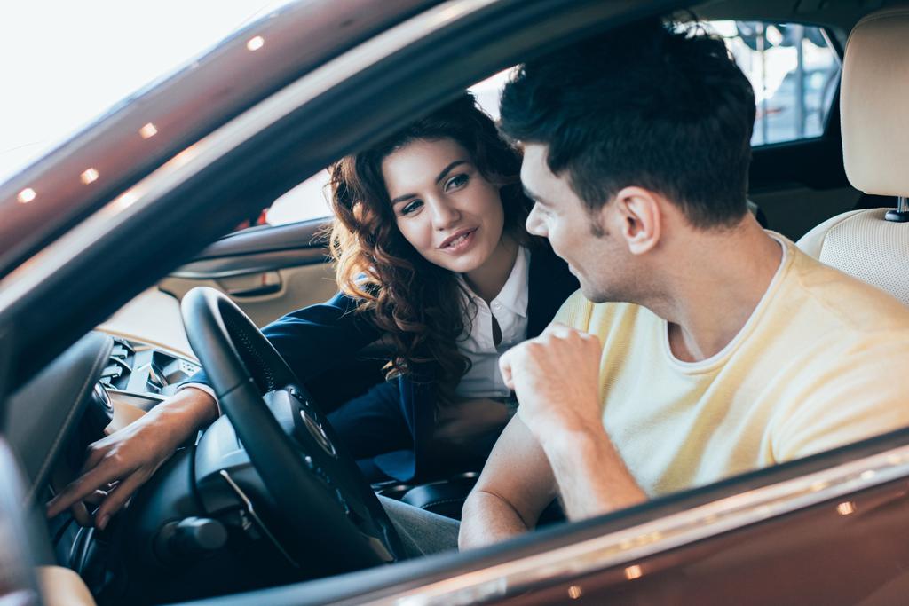 селективное внимание красивого мужчины и красивого автодилера, сидящего в машине
 - Фото, изображение