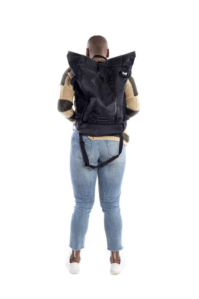 Mujer afroamericana negra con una mochila que mira el fondo blanco para composiciones. Ella es standiing como ella es un turista o un excursionista trekking
.  - Foto, imagen