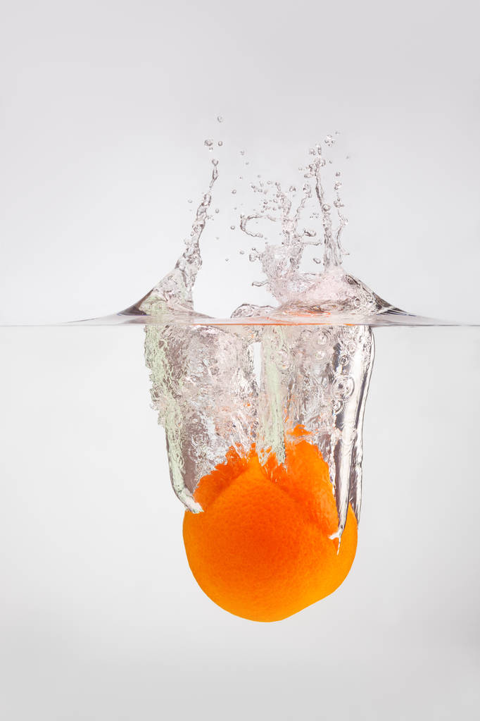 appelsiini putoaa veteen sirotellen paljon roiskeita ja dro
 - Valokuva, kuva