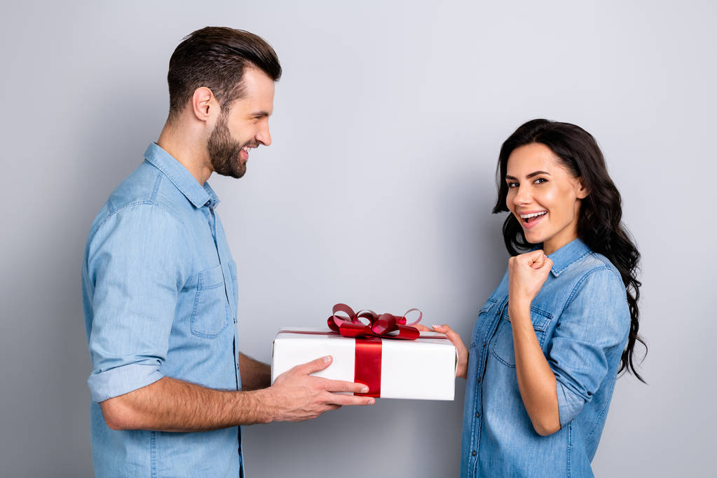Great finally Profile side view photo of beautiful successful wavy-hair casual student getting gift box from her stubble fellow raising fists dressed in blue denim shirts isolated argent background - Photo, Image