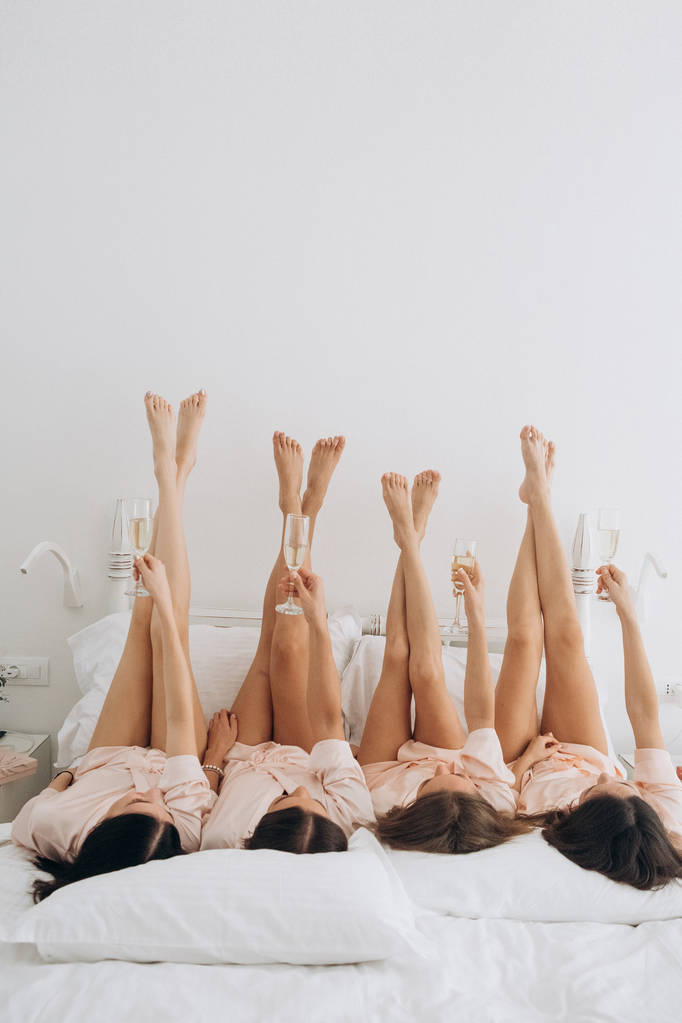 despedida de solteira cama deitado pernas taças de champanhe
 - Foto, Imagem
